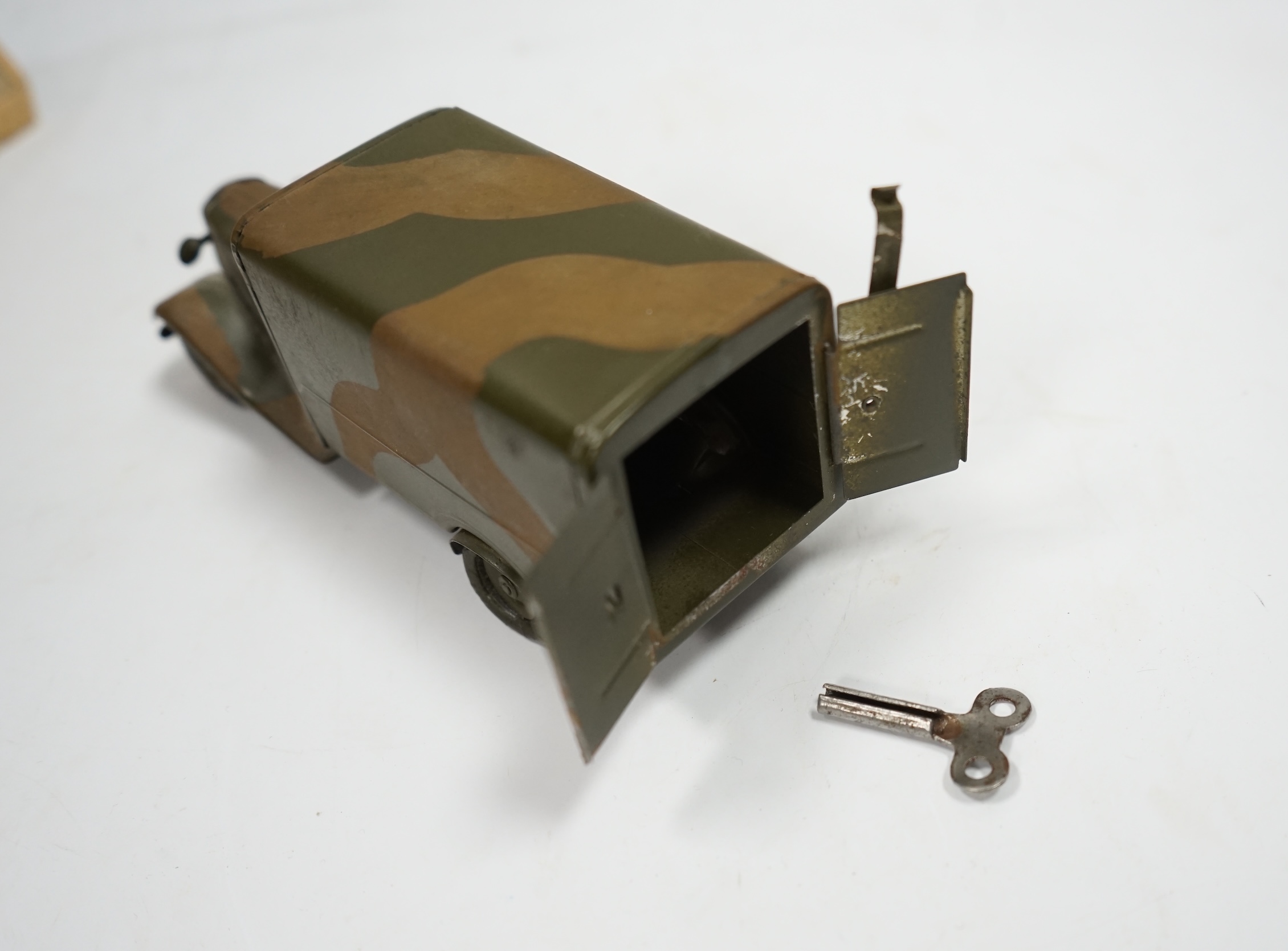 A Tri-ang Minic clockwork tinplate army lorry, in camouflage paint work, together with the remains of its box. Condition fair, original tires fatigued as expected, the box with missing flaps.